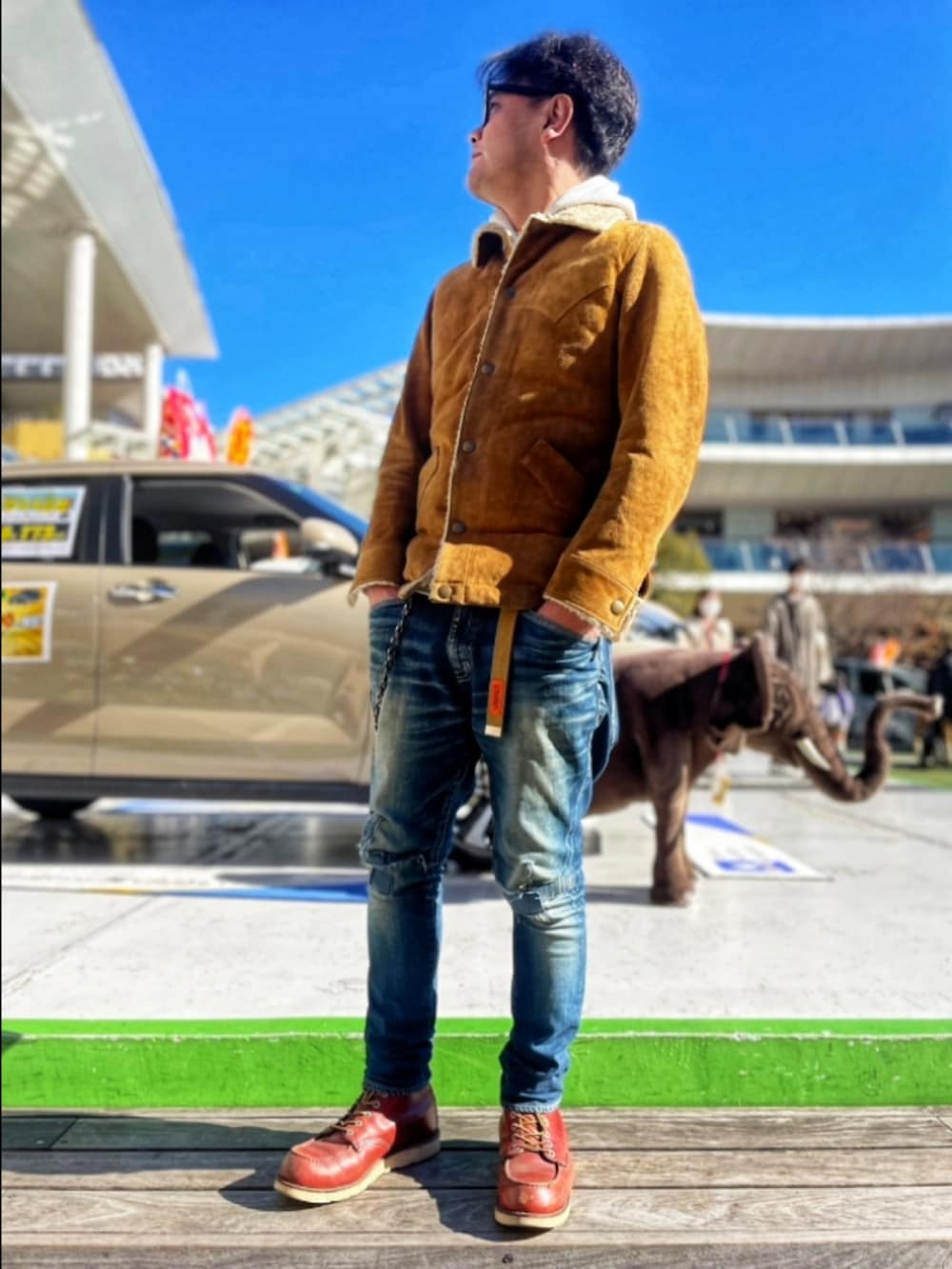 ブラウン系のジャケット/アウター、ブルー系のデニムパンツ、レッド系のブーツを着用したメンズの冬コーディネートの3枚目の写真