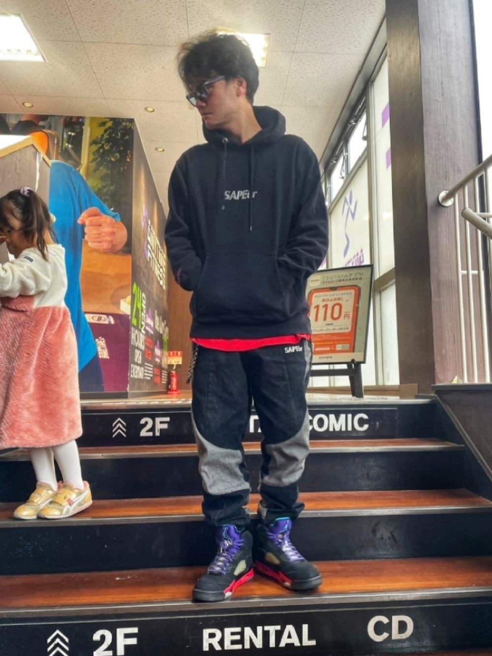 ブラック系のパーカー、ブラック系のデニムパンツ、その他のスニーカーを着用したメンズの冬コーディネートの2枚目の写真