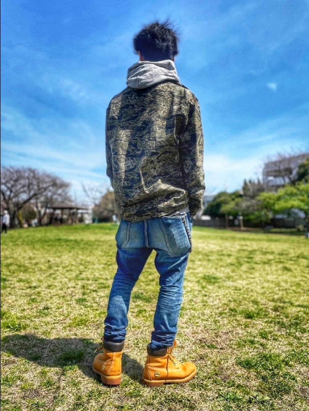 その他のミリタリージャケット、グレー系のパーカー、ブルー系のデニムパンツを着用したメンズの春コーディネートの3枚目の写真