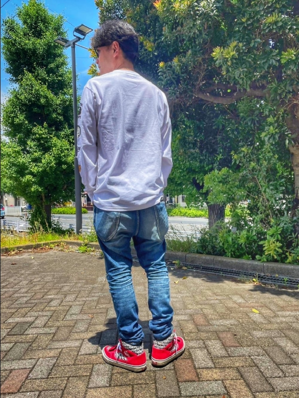 ホワイト系のTシャツ/カットソー、ブルー系のデニムパンツ、レッド系のスニーカーを着用したメンズの夏コーディネートの4枚目の写真