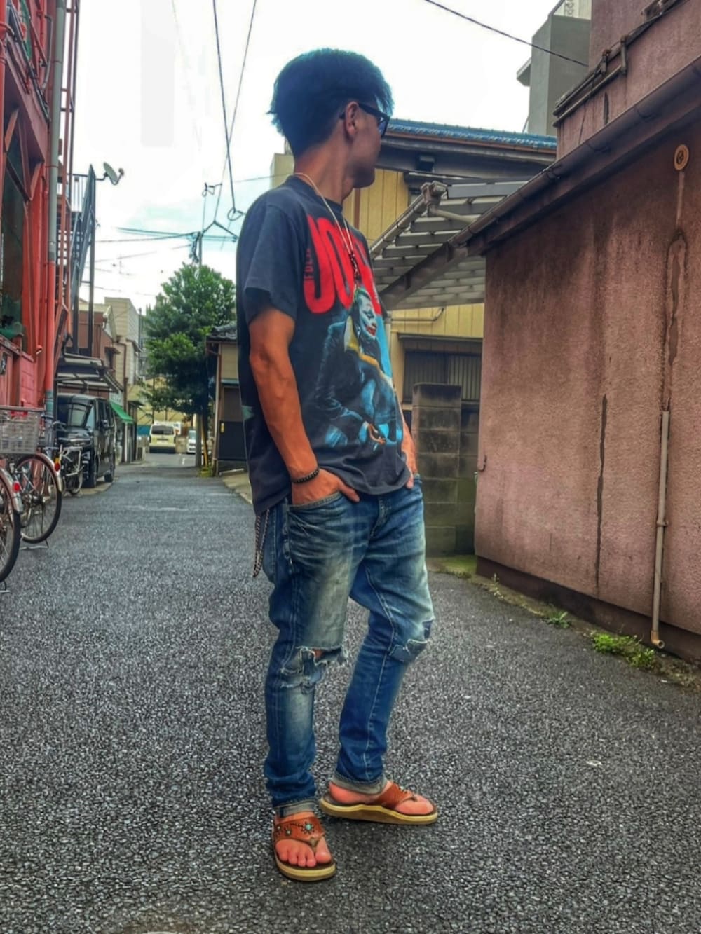 ブラック系のTシャツ/カットソー、ブルー系のデニムパンツ、ブラウン系のサンダルを着用したメンズの夏コーディネートの2枚目の写真