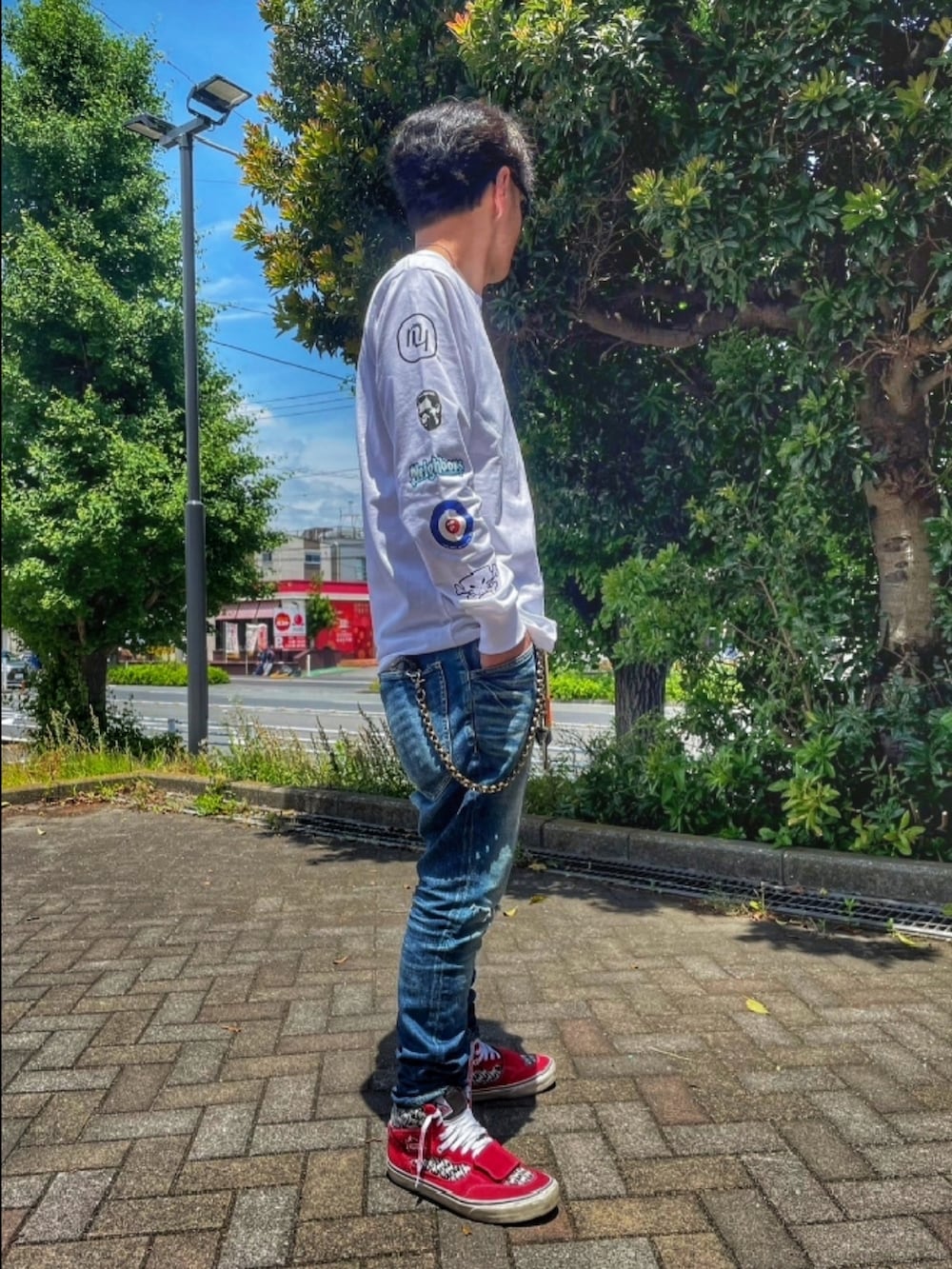 ホワイト系のTシャツ/カットソー、ブルー系のデニムパンツ、レッド系のスニーカーを着用したメンズの夏コーディネートの3枚目の写真