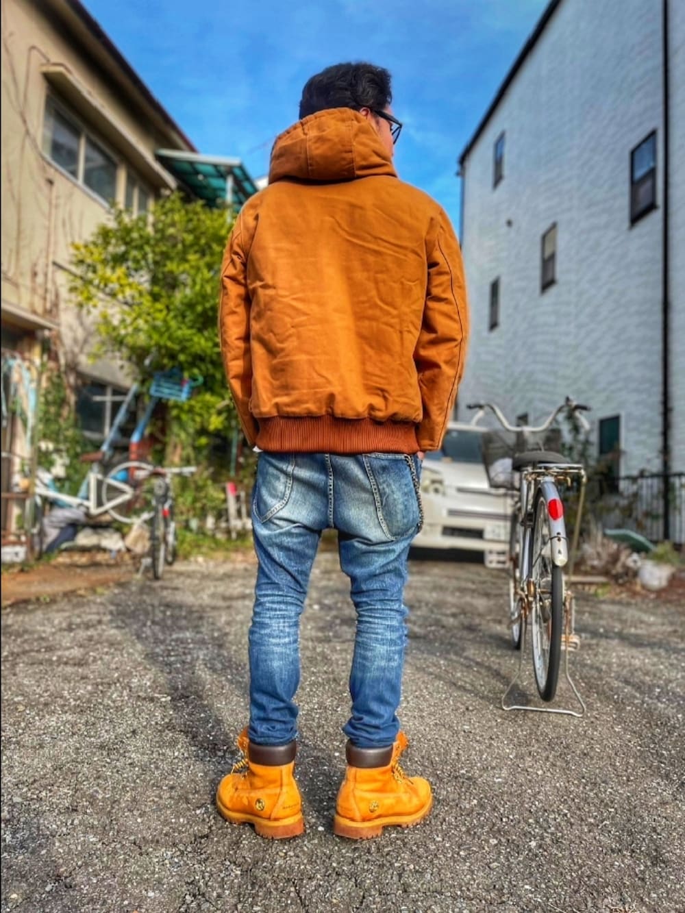 ブラウン系のブルゾン、ブルー系のデニムパンツ、イエロー系のブーツを着用したメンズの冬コーディネートの2枚目の写真