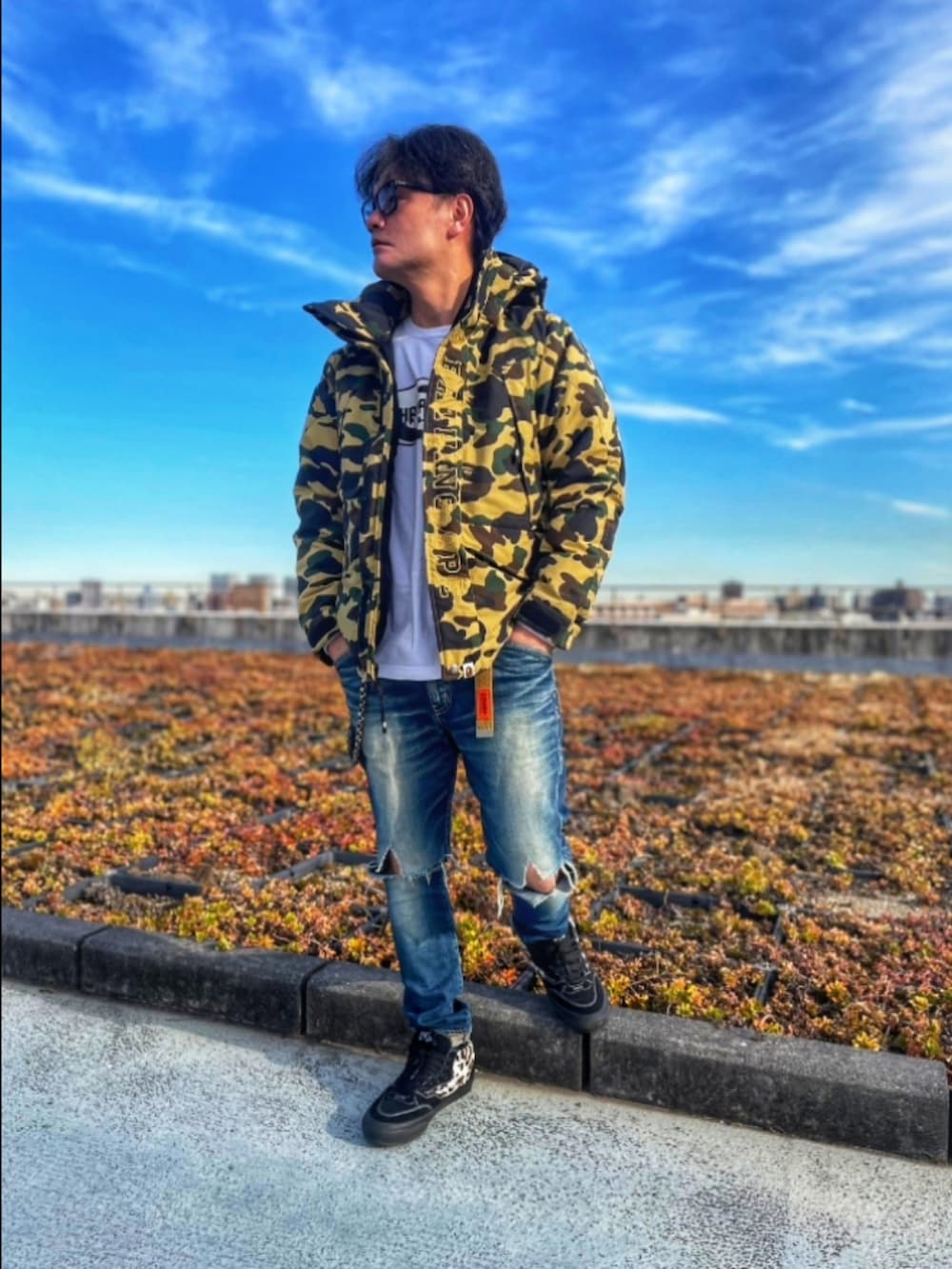 その他のダウンジャケット/コート、ブルー系のデニムパンツ、ブラック系のスニーカーを着用したメンズの冬コーディネートの2枚目の写真