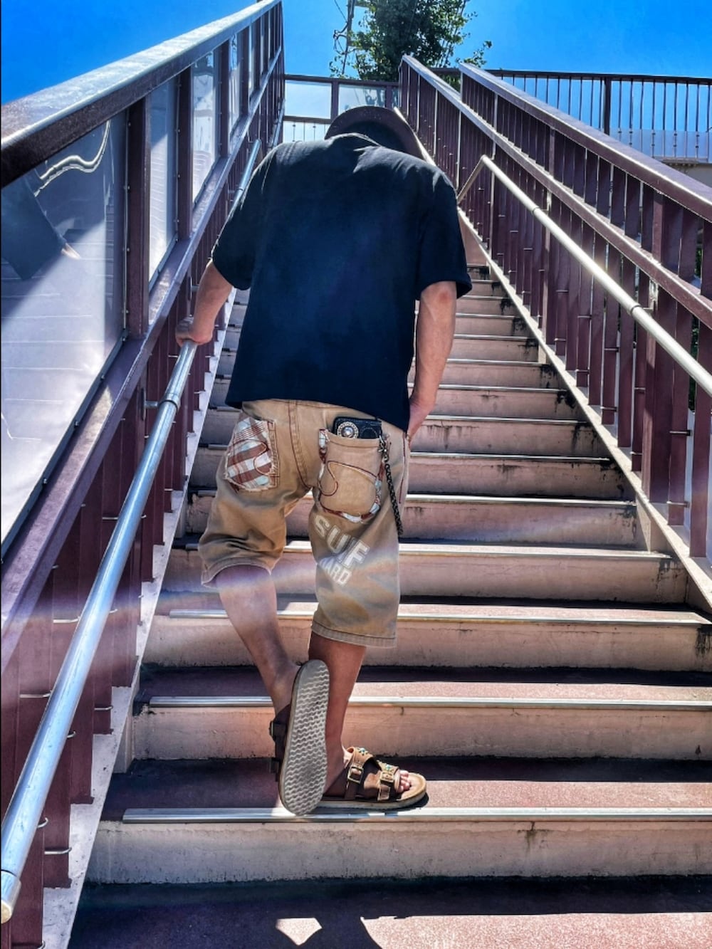 ブラック系のTシャツ/カットソー、ベージュ系のカーゴパンツ、ブラウン系のサンダルを着用したメンズの秋コーディネートの2枚目の写真