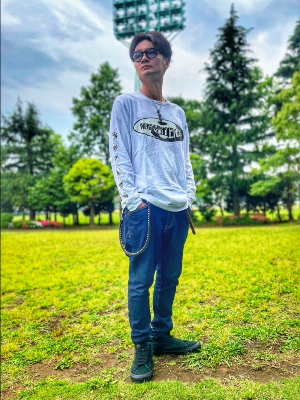 ホワイト系のTシャツ/カットソー、ブルー系のデニムパンツ、ブラック系のスニーカーを着用したメンズの夏コーディネートの2枚目の写真