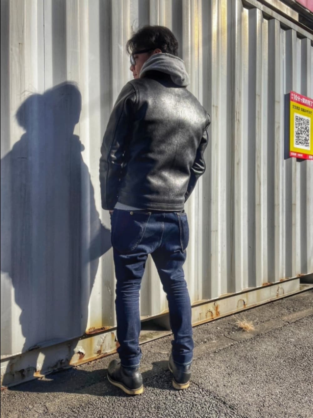 ブラック系のミリタリージャケット、ブルー系のデニムパンツ、ブラック系のブーツを着用したメンズの冬コーディネートの2枚目の写真