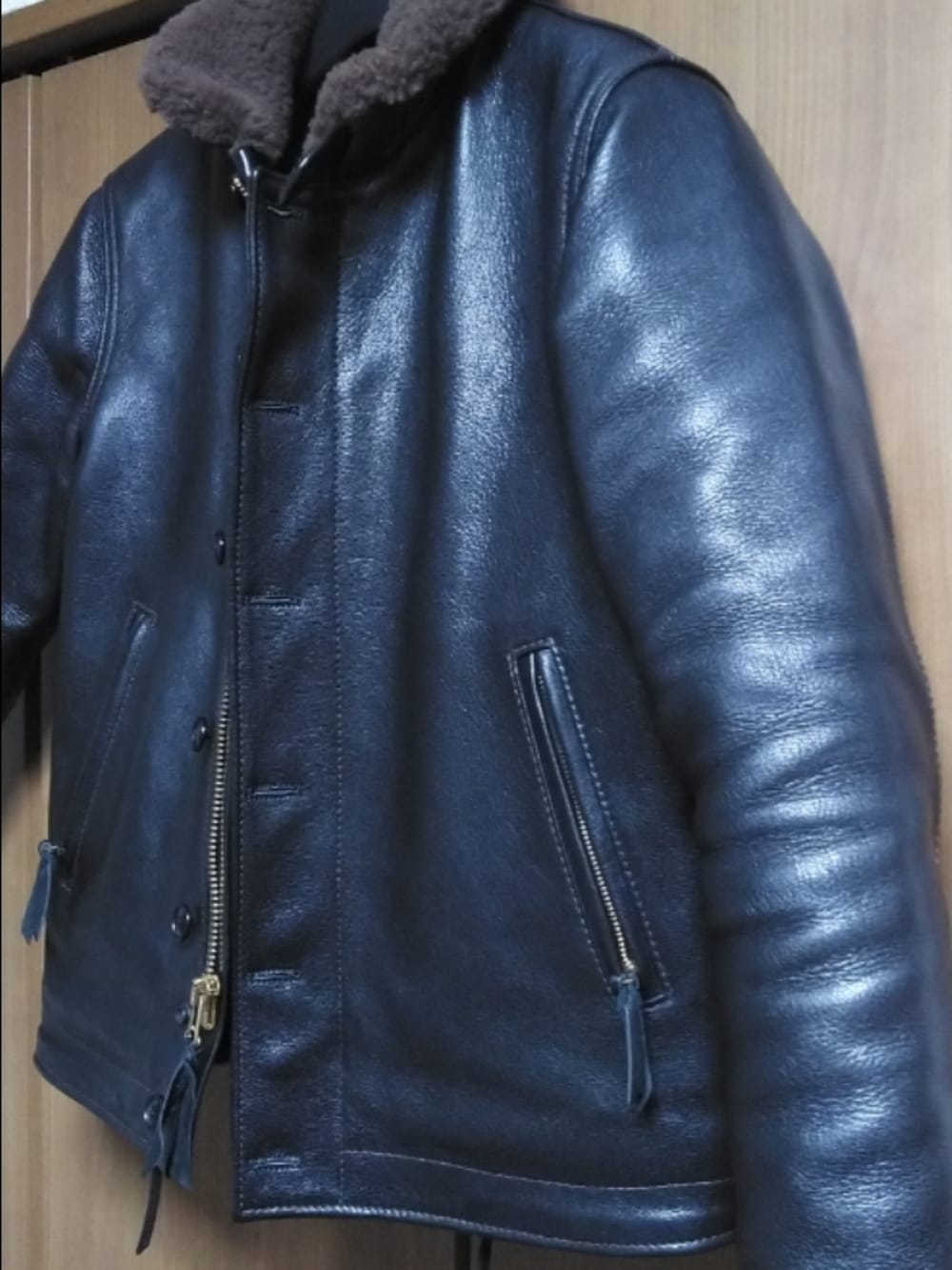 ブラック系のミリタリージャケット、ブルー系のデニムパンツ、ブラック系のブーツを着用したメンズの冬コーディネートの3枚目の写真