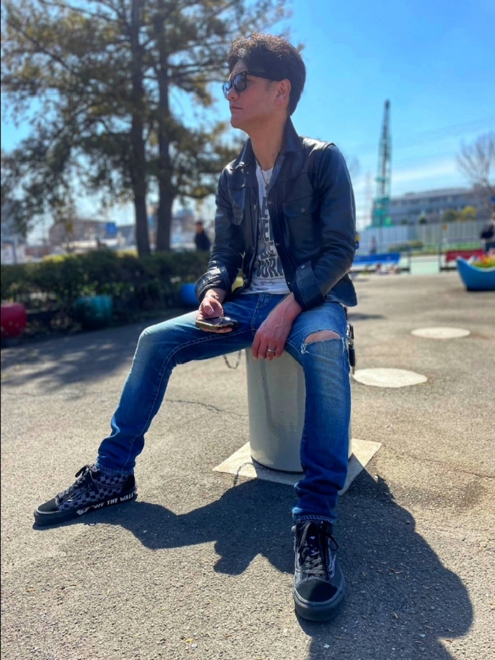 ブラック系のライダースジャケット、ホワイト系のTシャツ/カットソー、ブルー系のデニムパンツを着用したメンズの春コーディネートの2枚目の写真