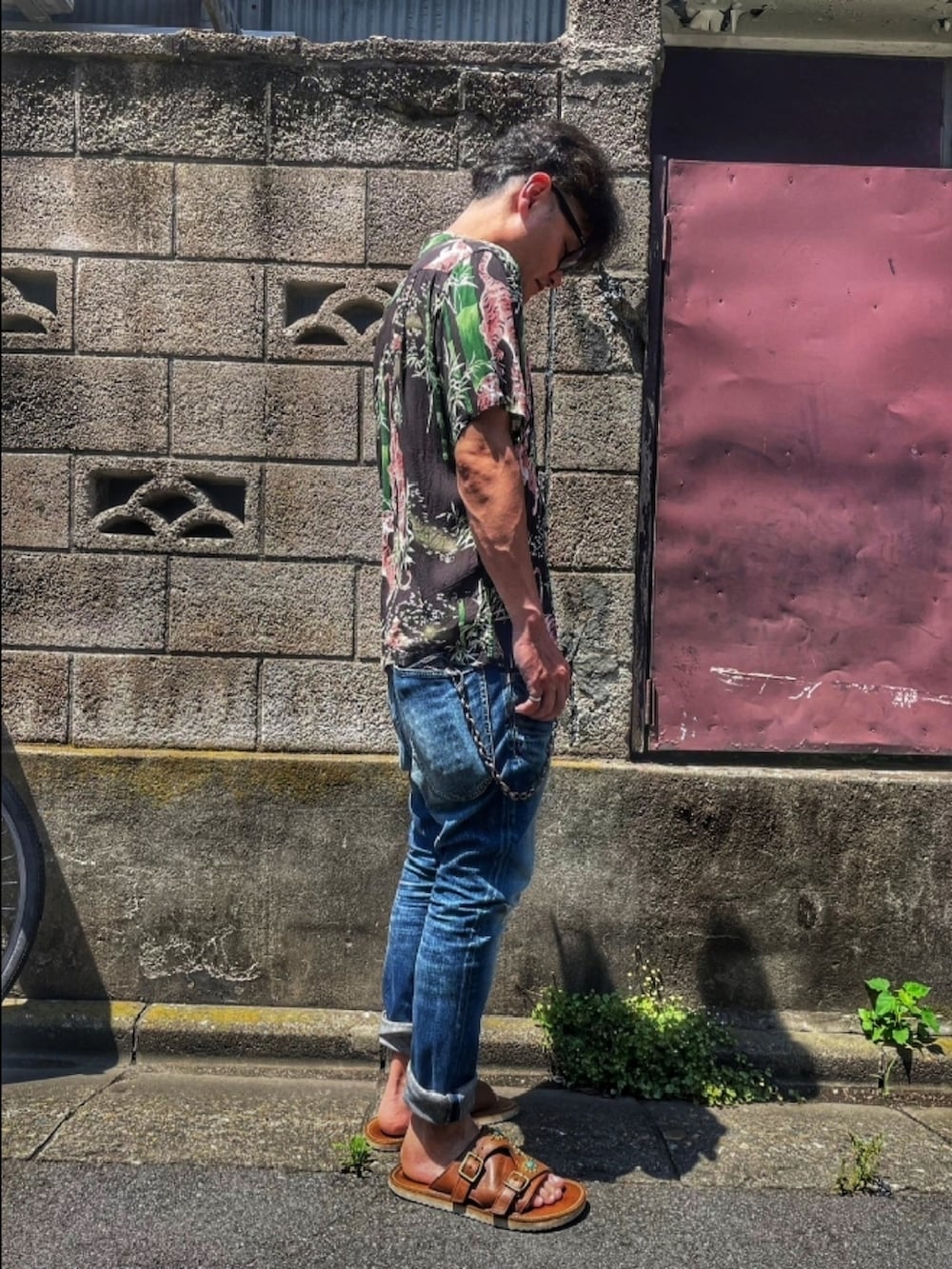 ブラック系のシャツ/ブラウス、ブルー系のデニムパンツ、ブラウン系のサンダルを着用したメンズの秋コーディネートの3枚目の写真