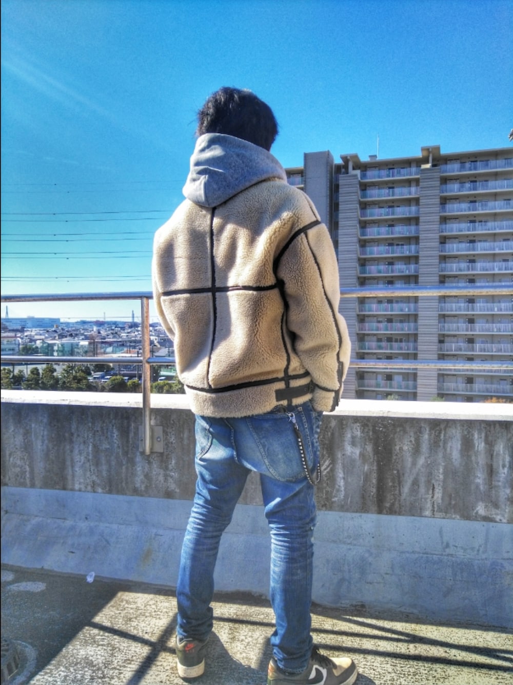 ベージュ系のブルゾン、ブルー系のデニムパンツ、グリーン系のスニーカーを着用したメンズの冬コーディネートの2枚目の写真