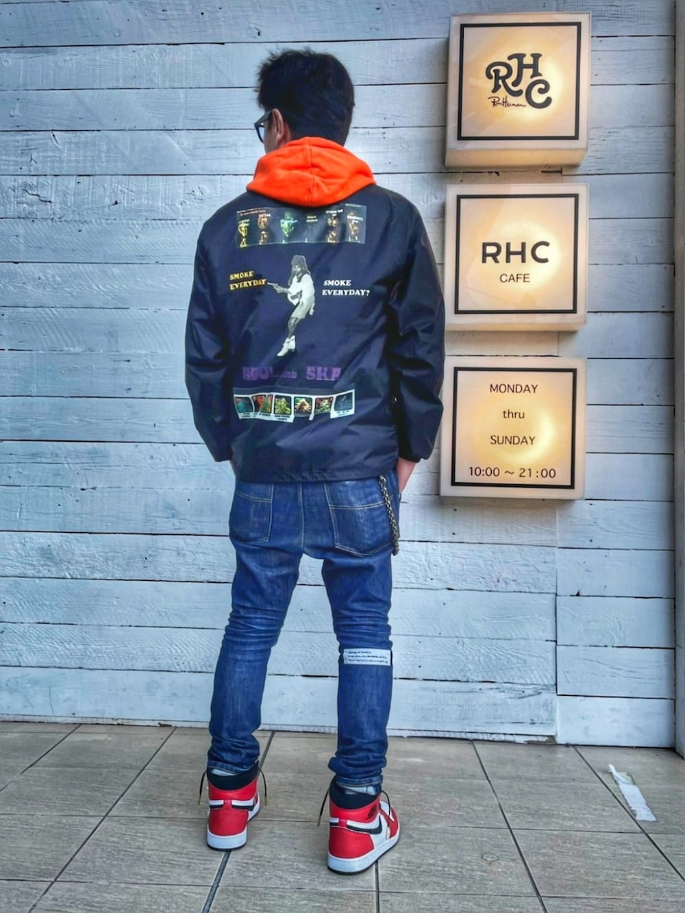ブラック系のナイロンジャケット、ブルー系のデニムパンツ、ホワイト系のスニーカーを着用したメンズの秋コーディネートの3枚目の写真