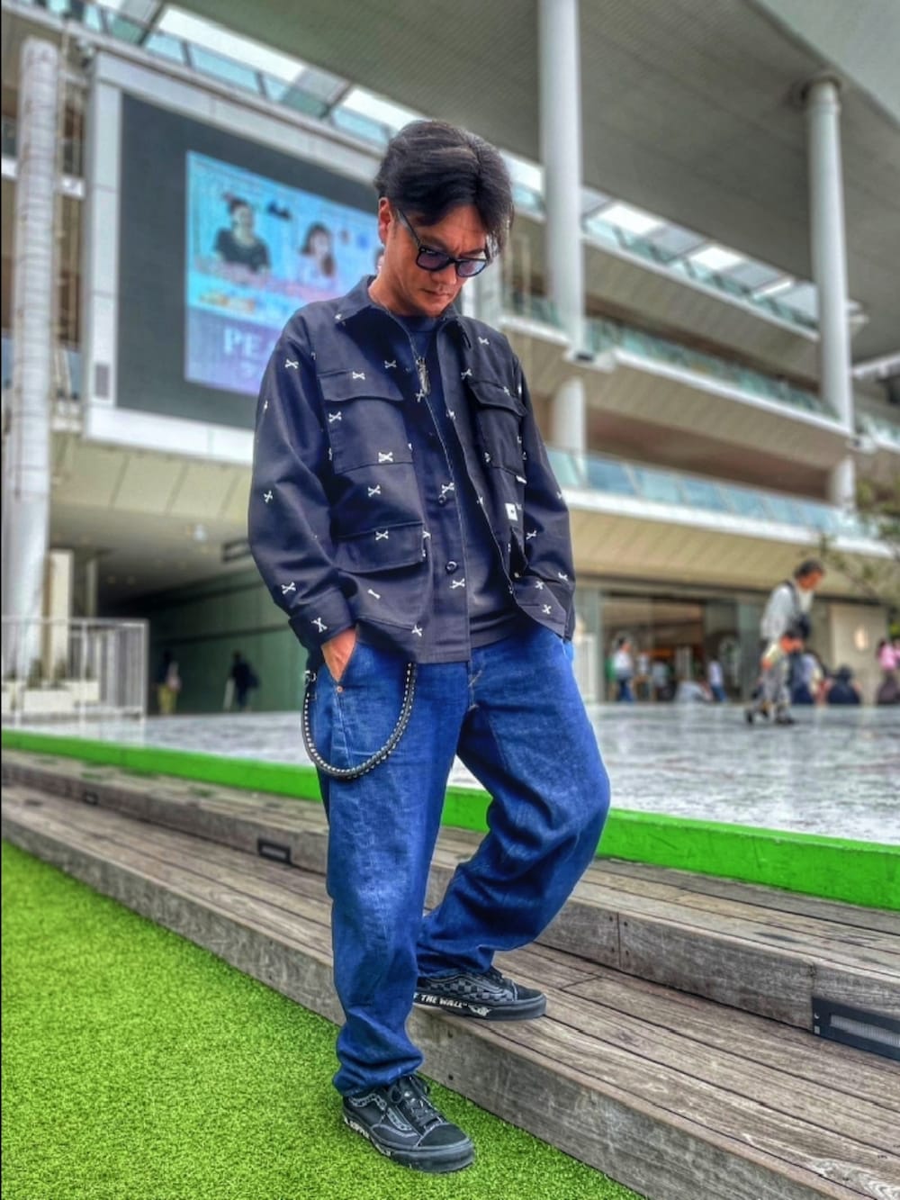 ブラック系のミリタリージャケット、ブラック系のTシャツ/カットソー、ブルー系のデニムパンツを着用したメンズの春コーディネートの3枚目の写真