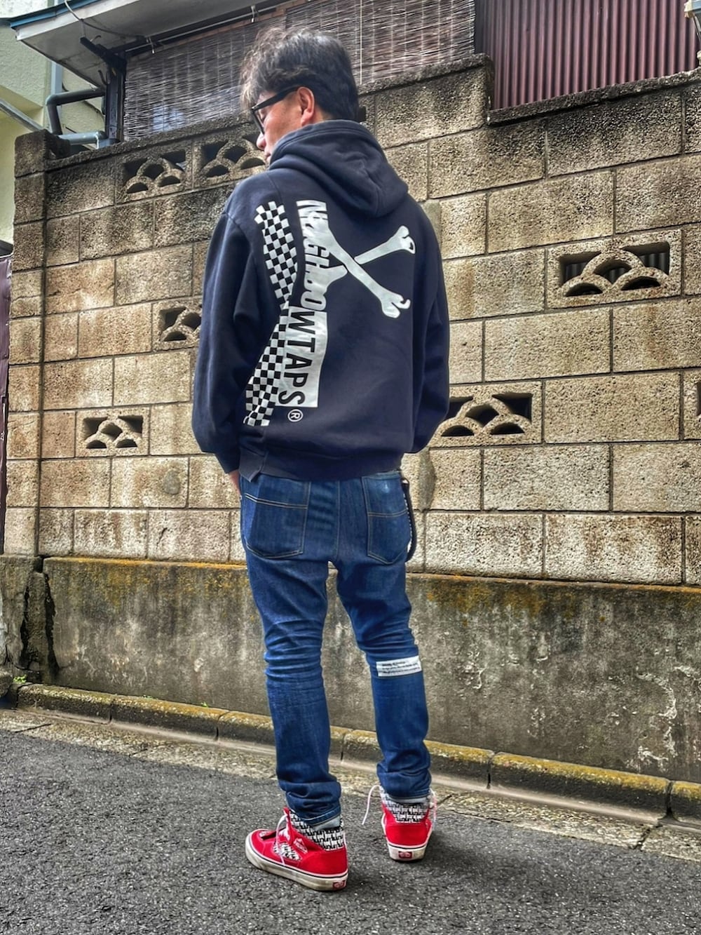 ブラック系のパーカー、ブルー系のデニムパンツ、レッド系のスニーカーを着用したメンズの春コーディネートの3枚目の写真