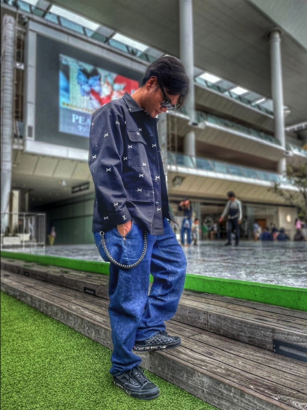 ブラック系のミリタリージャケット、ブラック系のTシャツ/カットソー、ブルー系のデニムパンツを着用したメンズの春コーディネートの2枚目の写真