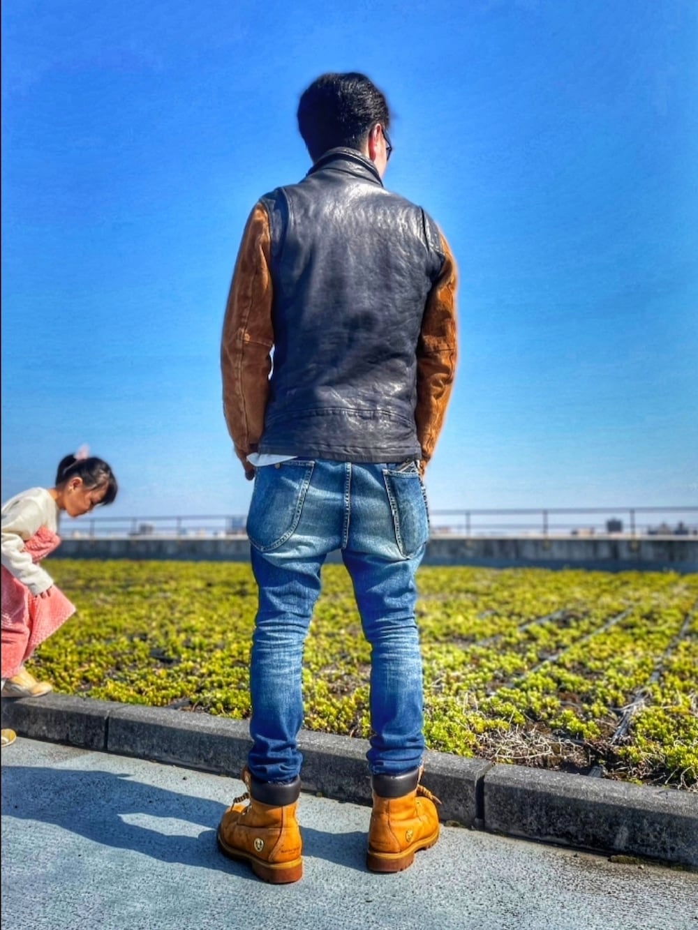 ブルー系のライダースジャケット、ブルー系のデニムパンツ、イエロー系のブーツを着用したメンズの春コーディネートの3枚目の写真