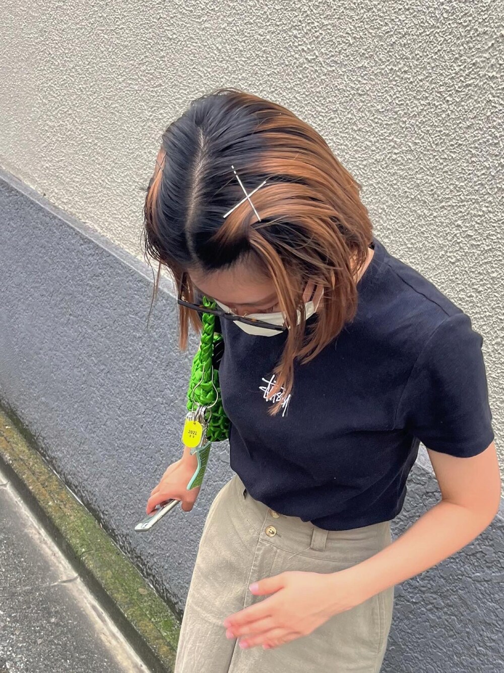 ブラック系のTシャツ/カットソー、ベージュ系のスカート、ブラック系のスニーカーを着用したレディースの夏コーディネートの2枚目の写真