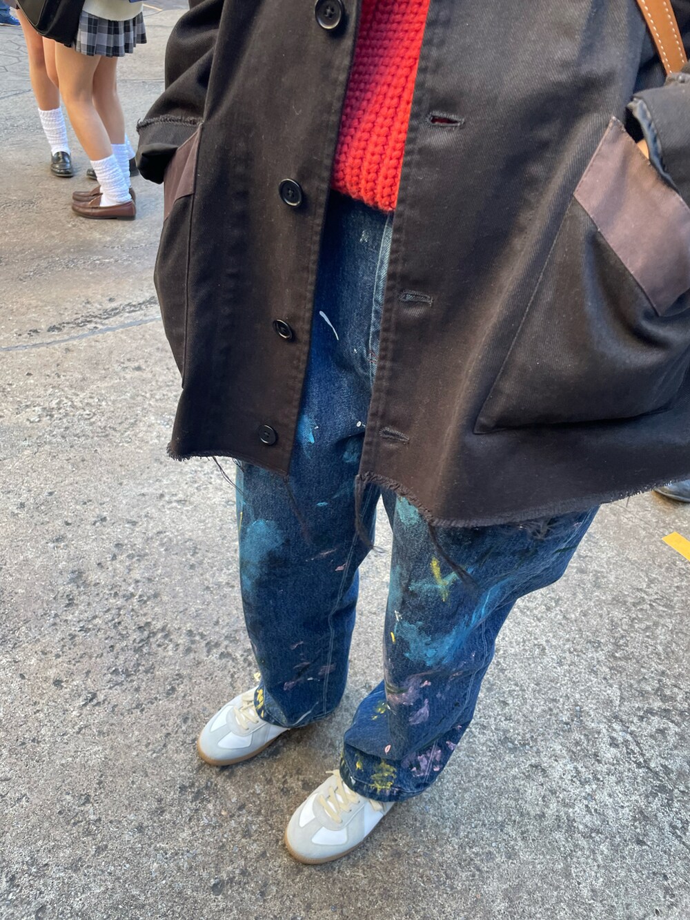 ベージュ系のスニーカー、ブルー系のデニムパンツ、ブラック系のテーラードジャケットを着用したレディースの春コーディネートの3枚目の写真