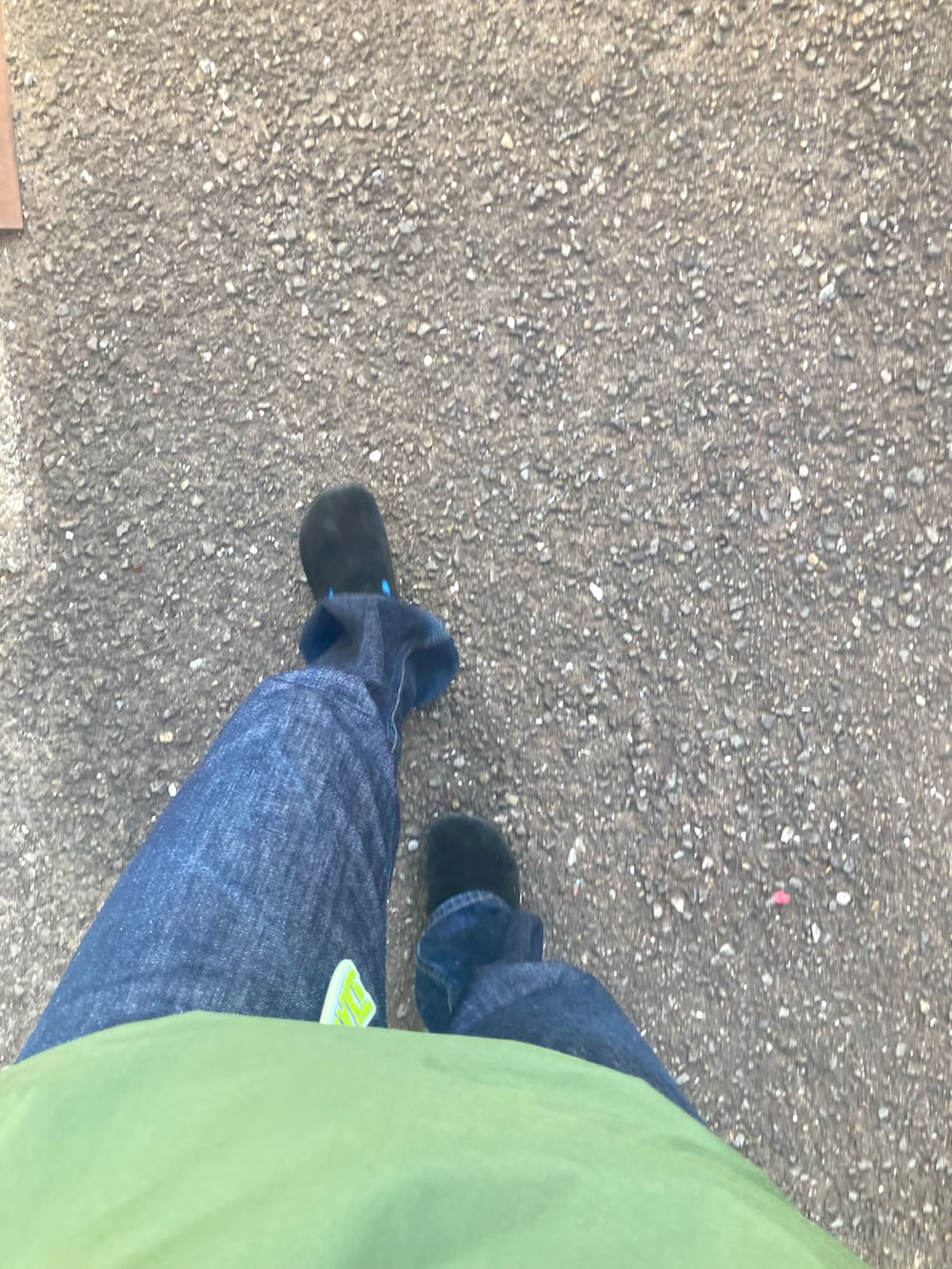 ブラック系のステンカラーコート、ベージュ系のメッセンジャーバッグ、ブルー系のキャップを着用したレディースの春コーディネートの2枚目の写真