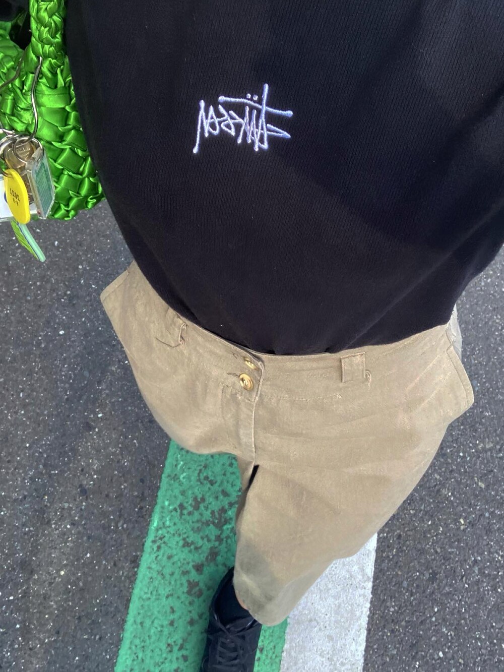 ブラック系のTシャツ/カットソー、ベージュ系のスカート、ブラック系のスニーカーを着用したレディースの夏コーディネートの3枚目の写真