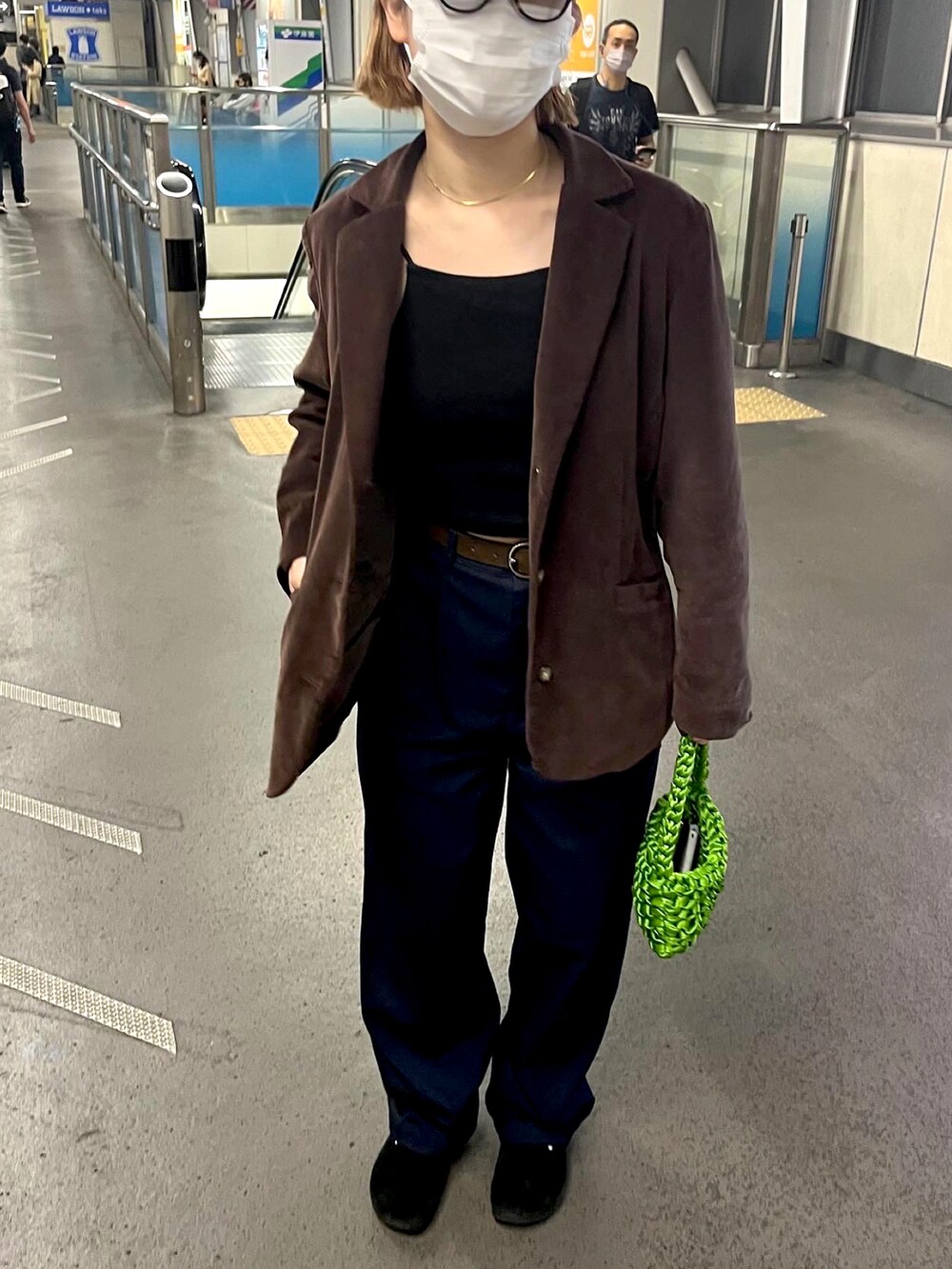 ブルー系のスラックス、ブラック系のサンダル、ブラウン系のテーラードジャケットを着用したレディースの春コーディネートの2枚目の写真