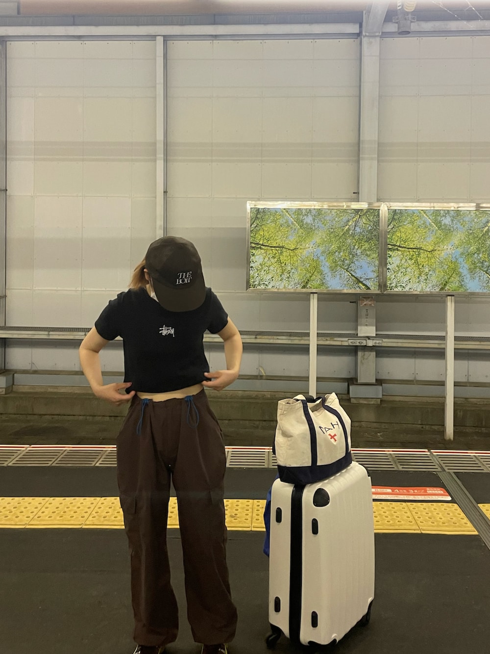 ブラック系のTシャツ/カットソー、ブラウン系のシューズ、ブラウン系のキャップを着用したレディースの夏コーディネートの2枚目の写真