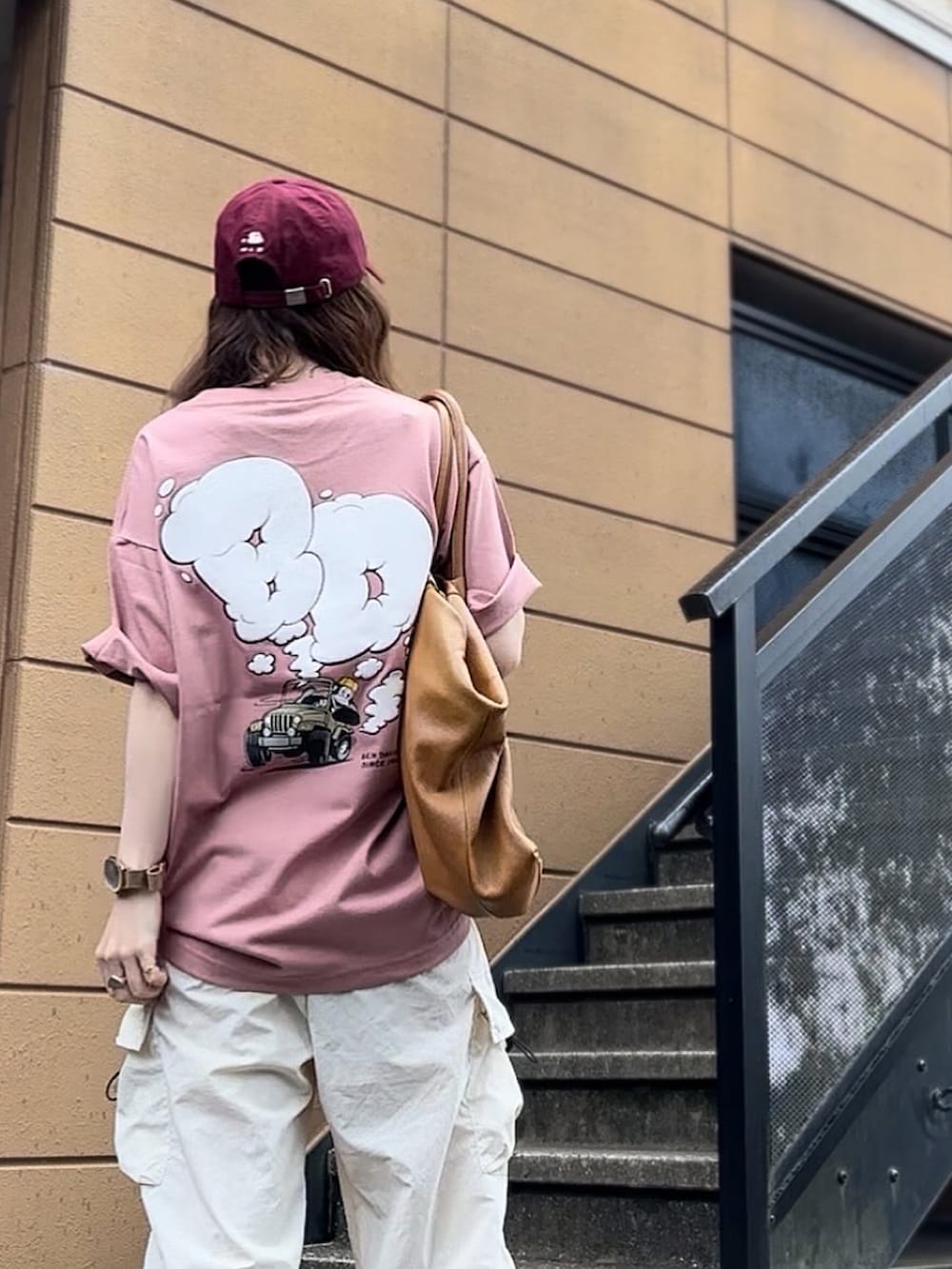 ピンク系のTシャツ/カットソー、レッド系のキャップを着用したレディースの夏コーディネートの2枚目の写真