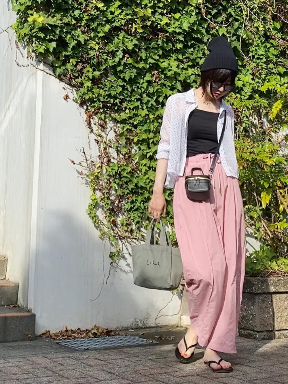 ブラック系のショルダーバッグ、ブラック系のサンダル、ブラック系のニットキャップ/ビーニーを着用したレディースの秋コーディネートの2枚目の写真