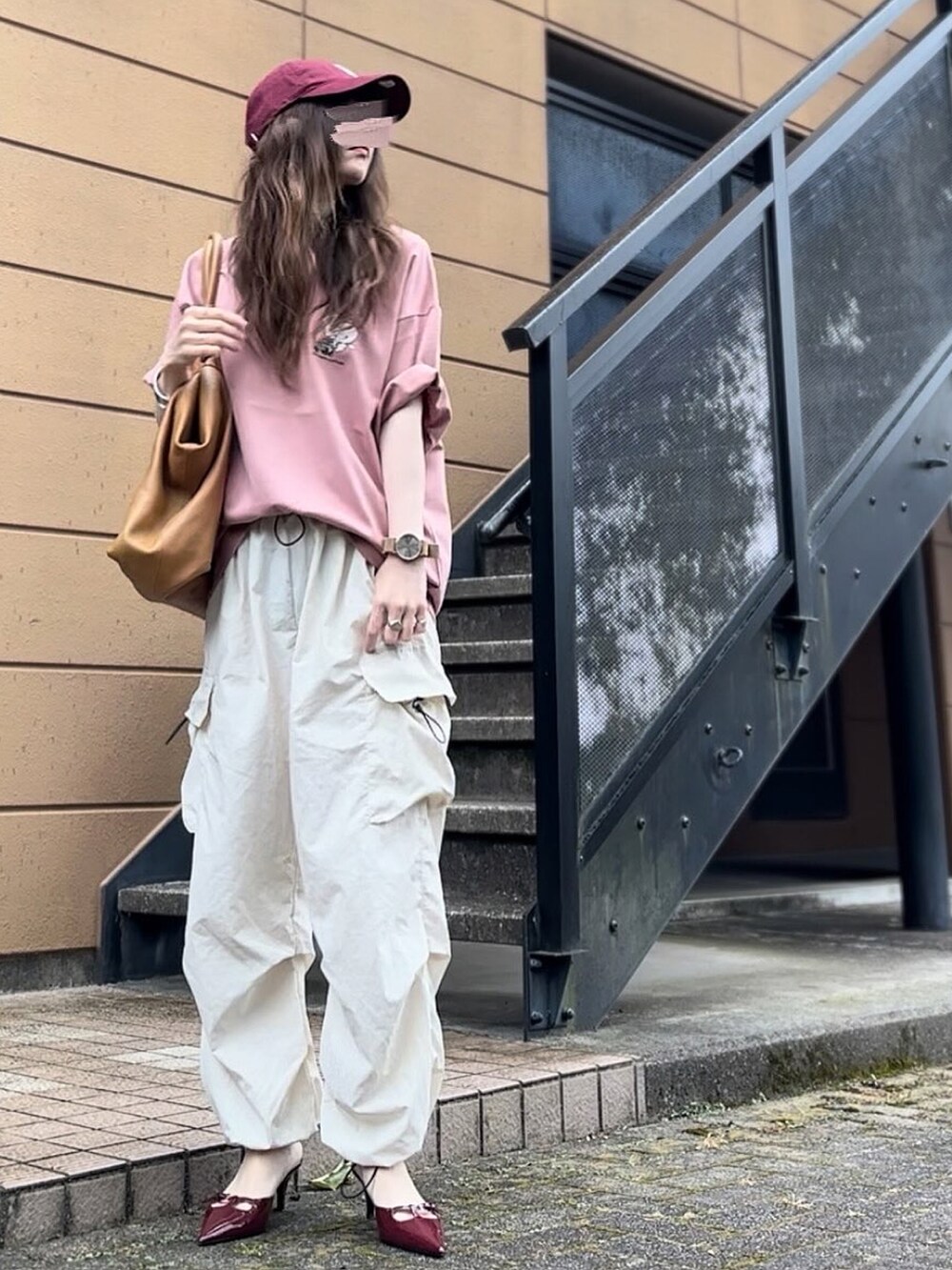 ピンク系のTシャツ/カットソー、レッド系のキャップを着用したレディースの夏コーディネートの3枚目の写真