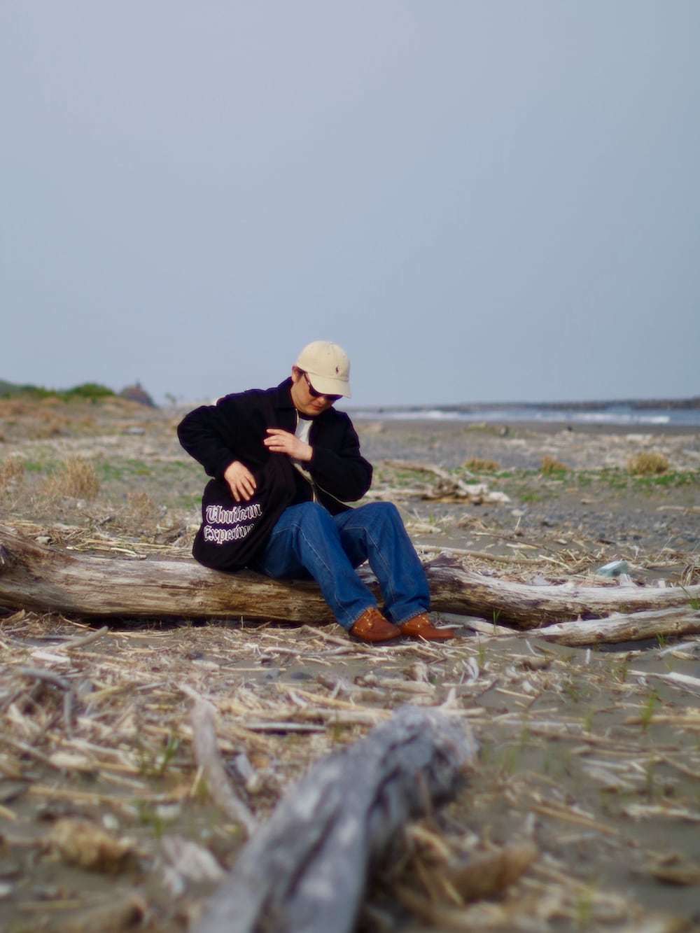 ホワイト系のTシャツ/カットソー、ブラック系のブルゾン、ブルー系のデニムパンツを着用したメンズの春コーディネートの3枚目の写真