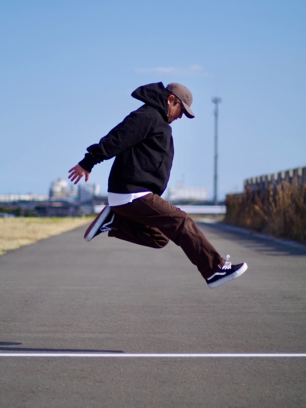 ブラック系のその他アウター、ブラウン系のチノパンツ、ブラック系のスニーカーを着用したメンズの春コーディネートの2枚目の写真