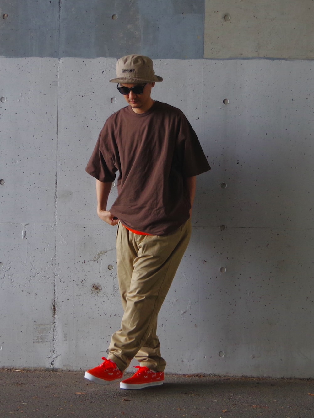 オレンジ系のスニーカー、ベージュ系のその他パンツ、ブラウン系のTシャツ/カットソーを着用したメンズの夏コーディネートの3枚目の写真