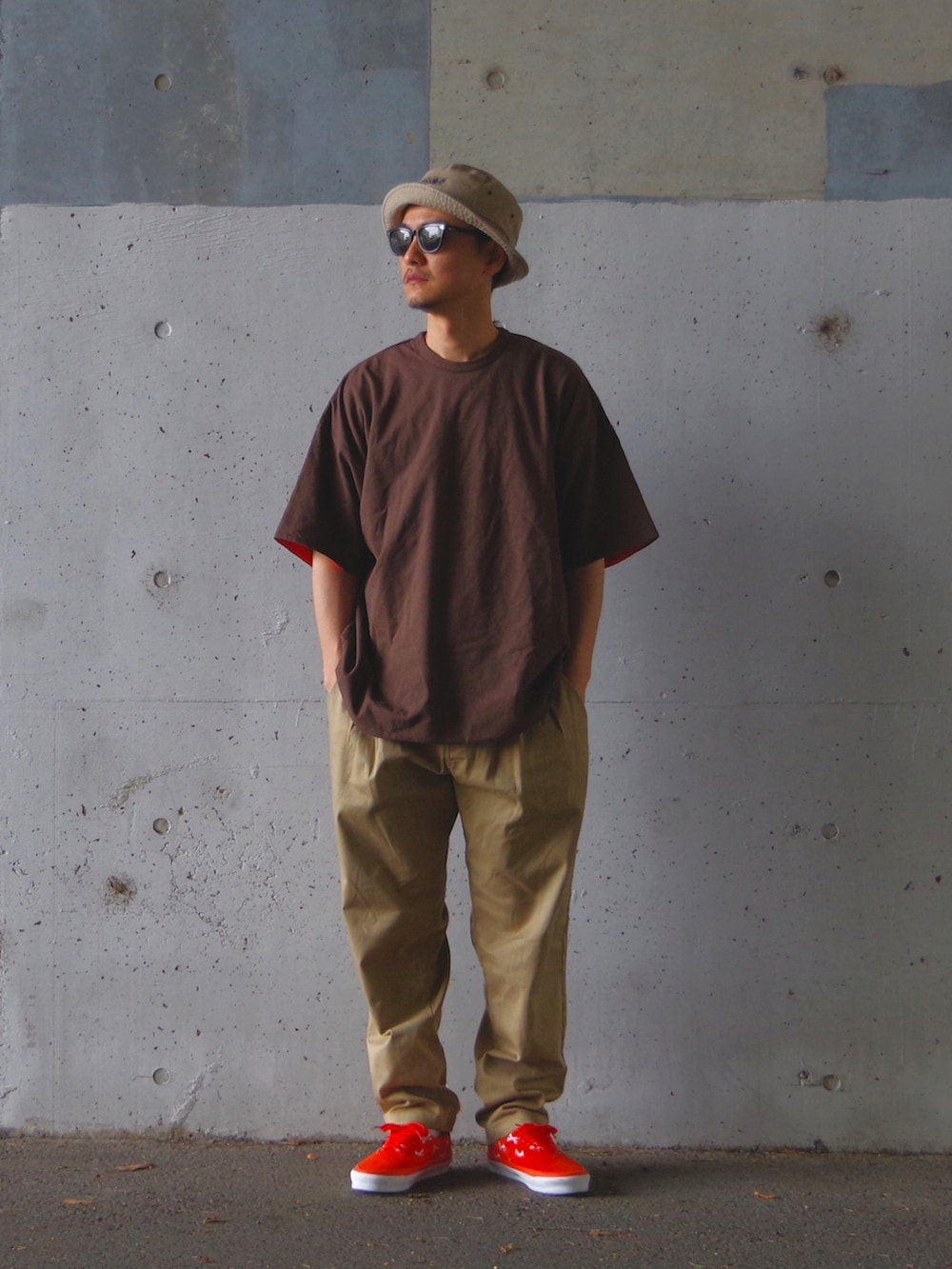 オレンジ系のスニーカー、ベージュ系のその他パンツ、ブラウン系のTシャツ/カットソーを着用したメンズの夏コーディネートの2枚目の写真
