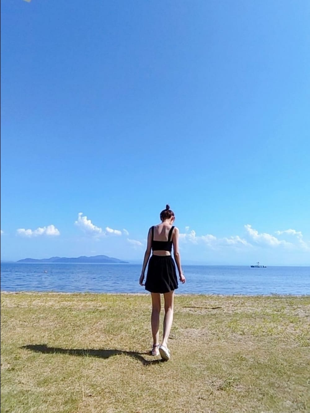 ブラック系の水着、ブラック系のラッシュガードを着用したレディースの夏コーディネートの2枚目の写真