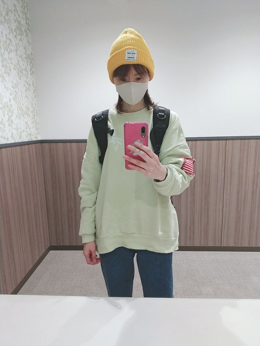 ブルー系のデニムパンツ、ブラック系のバックパック/リュック、ホワイト系のスニーカーを着用したレディースの秋コーディネートの4枚目の写真