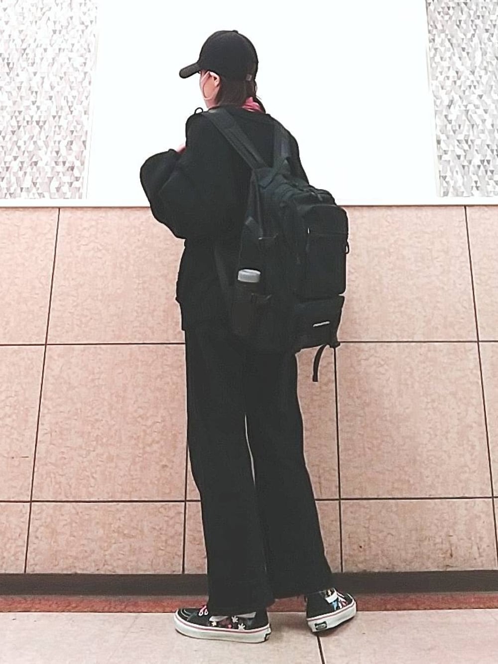 ブラック系のスニーカー、ブラック系のバックパック/リュック、ブラック系のキャップを着用したレディースの春コーディネートの2枚目の写真