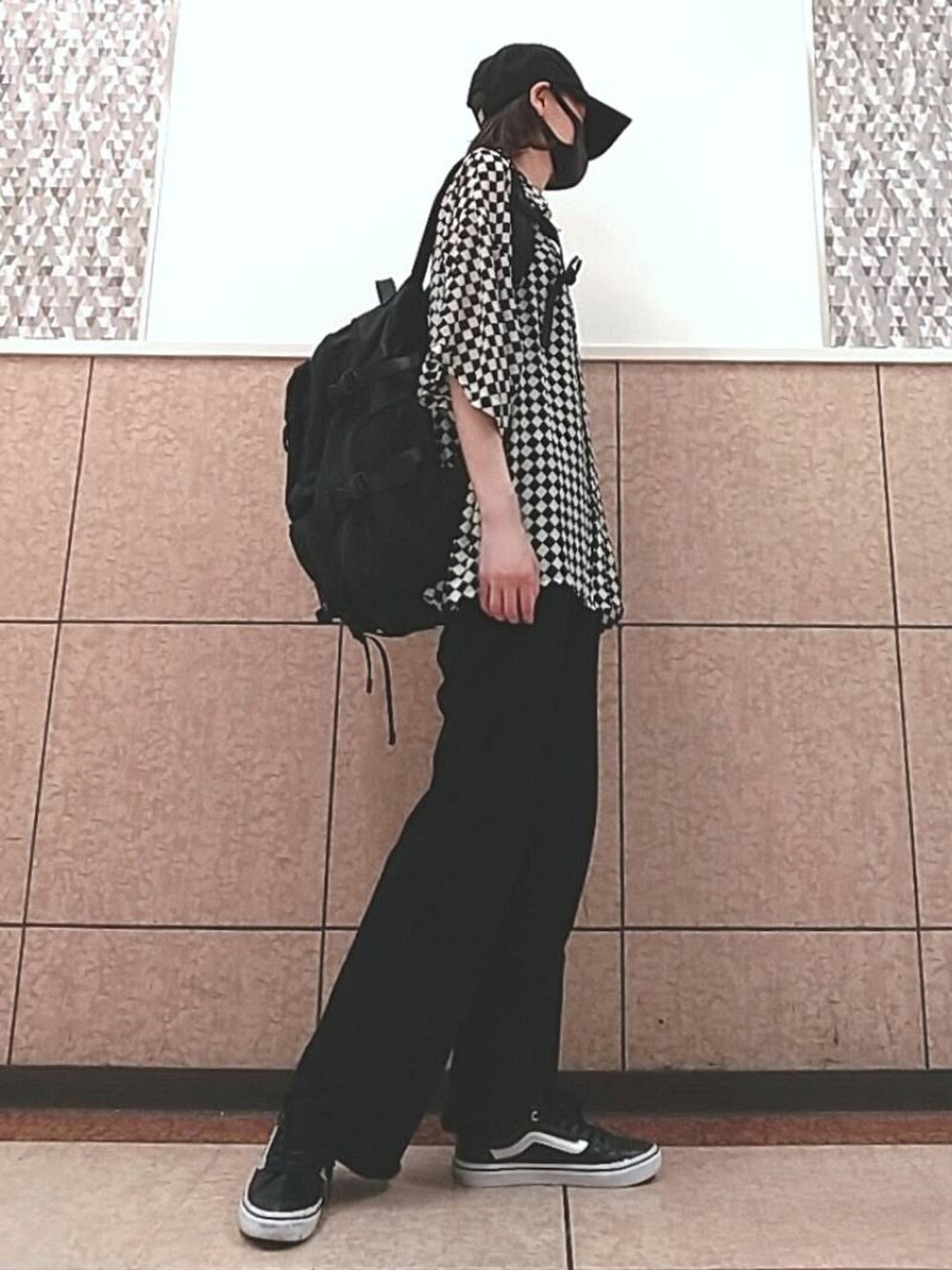 ブラック系のスラックス、ブラック系のスニーカー、ブラック系のバックパック/リュックを着用したレディースの夏コーディネートの2枚目の写真