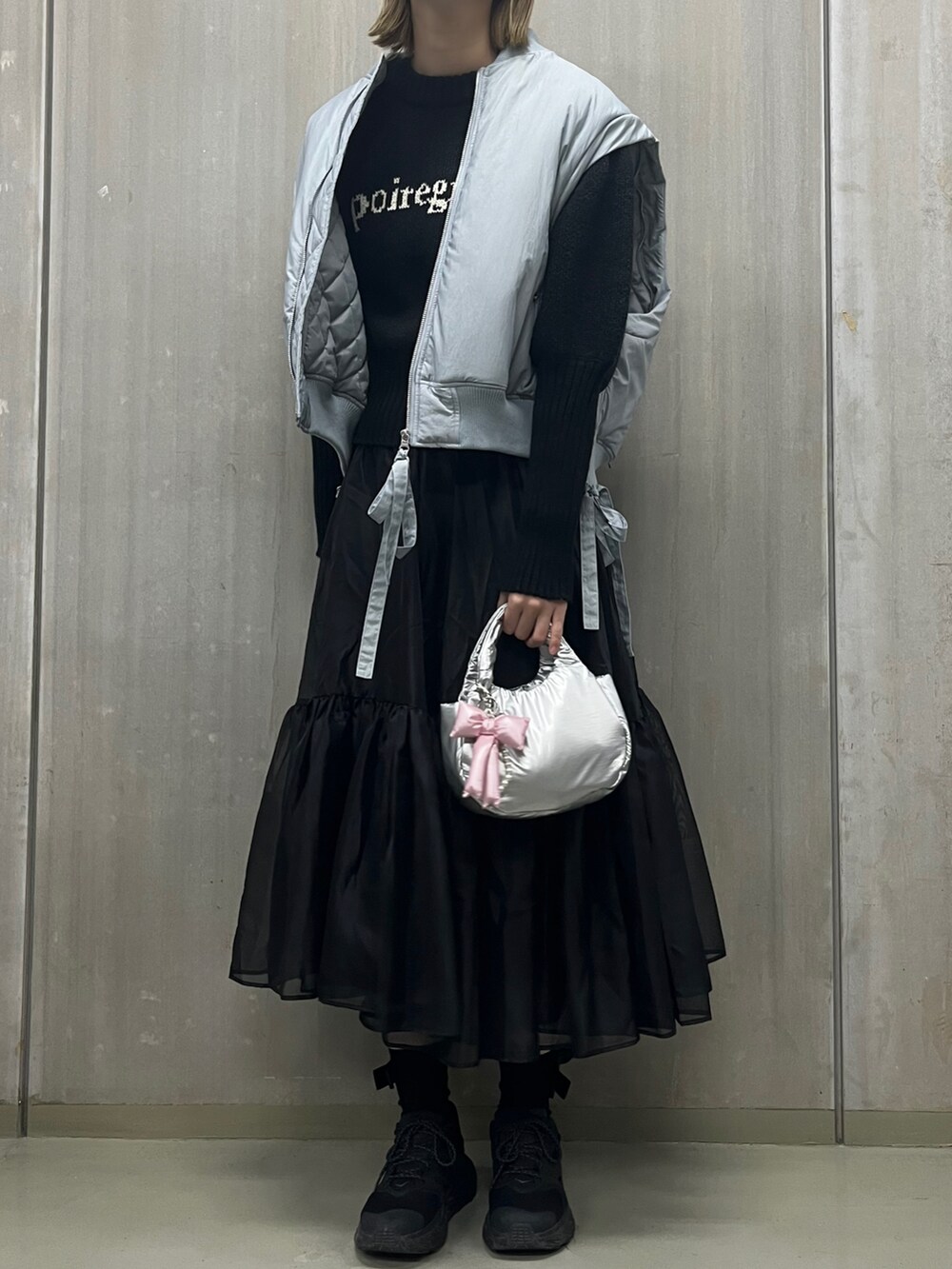 ブルー系のMA-1、ブラック系のニット/セーター、ブラック系のスカートを着用したレディースの秋コーディネートの2枚目の写真