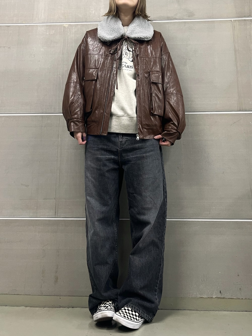 ブラウン系のブルゾン、ベージュ系のスウェット、ホワイト系のトートバッグを着用したレディースの冬コーディネートの2枚目の写真