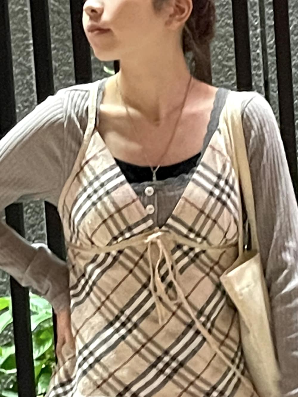 ベージュ系のトートバッグ、ベージュ系のチューブトップ、ブラック系のスリッポンを着用したレディースの秋コーディネートの3枚目の写真