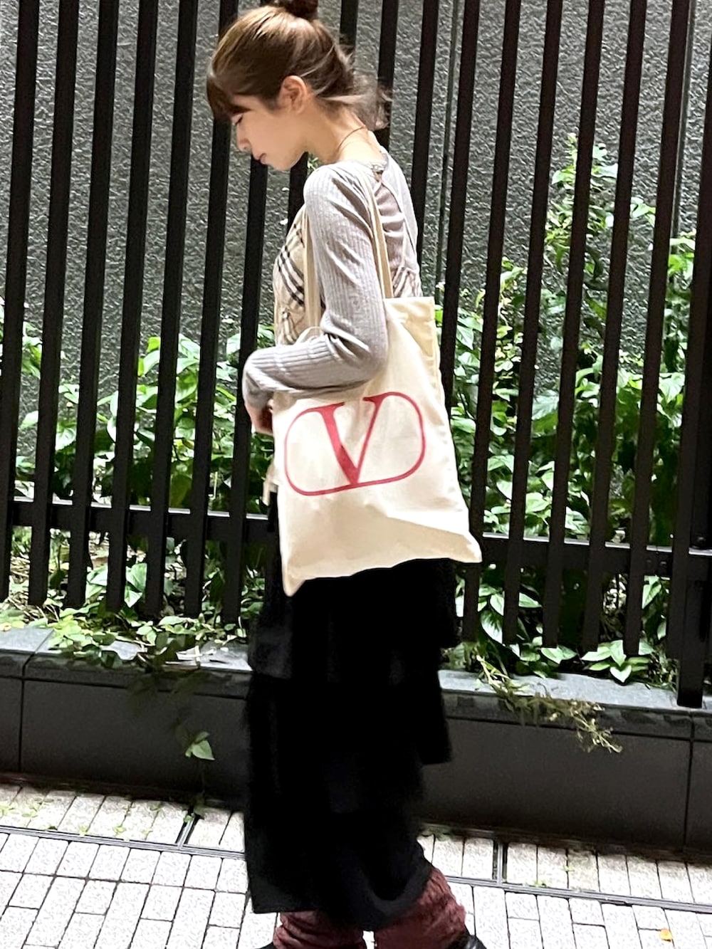 ベージュ系のトートバッグ、ベージュ系のチューブトップ、ブラック系のスリッポンを着用したレディースの秋コーディネートの2枚目の写真