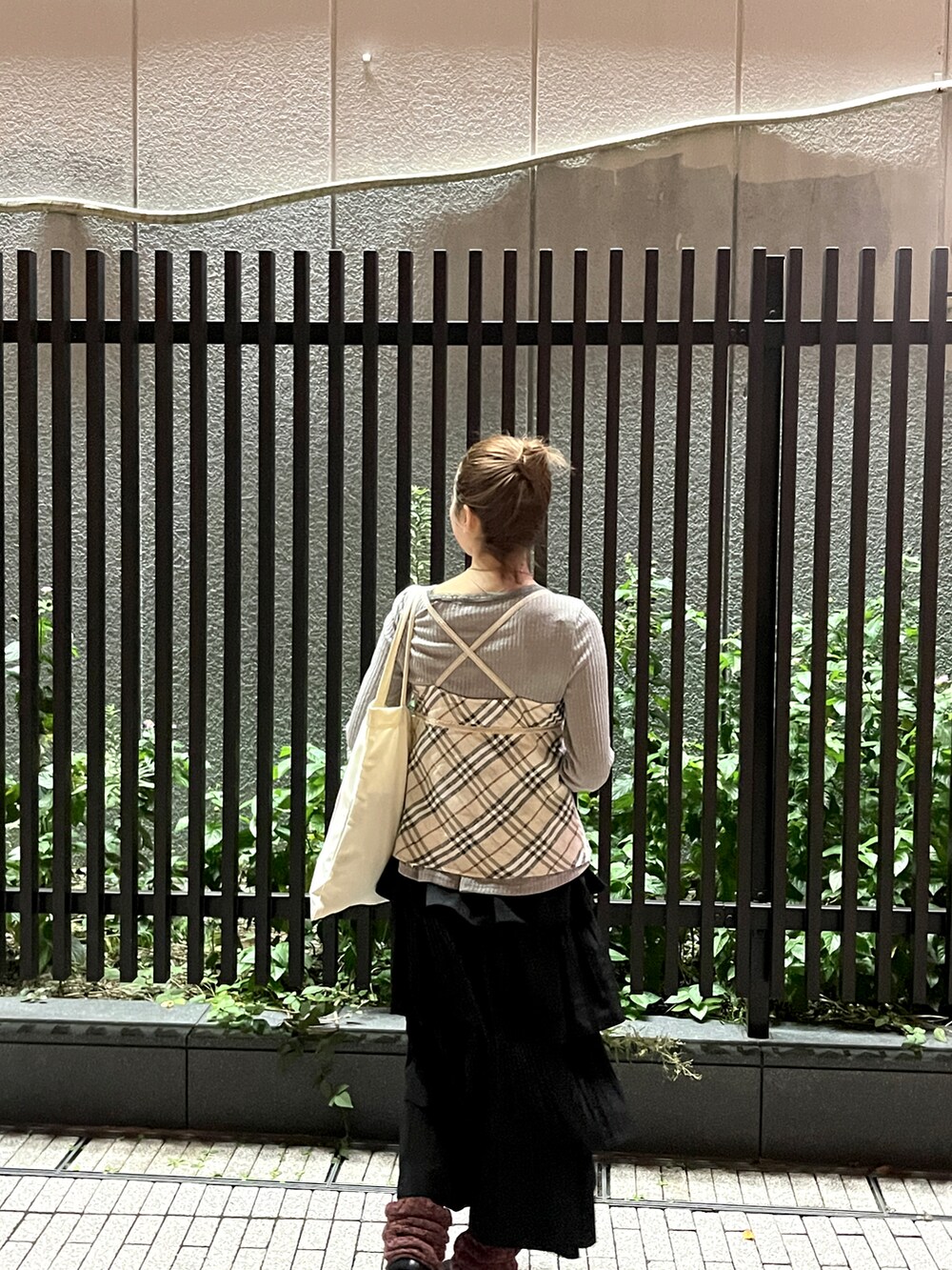 ベージュ系のトートバッグ、ベージュ系のチューブトップ、ブラック系のスリッポンを着用したレディースの秋コーディネートの4枚目の写真