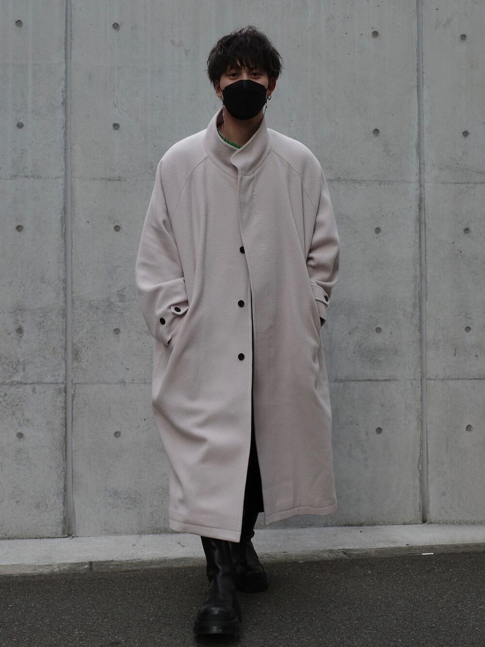 ホワイト系のノーカラーコート、グリーン系のニット/セーター、ブラック系のデニムパンツを着用したメンズの冬コーディネートの2枚目の写真