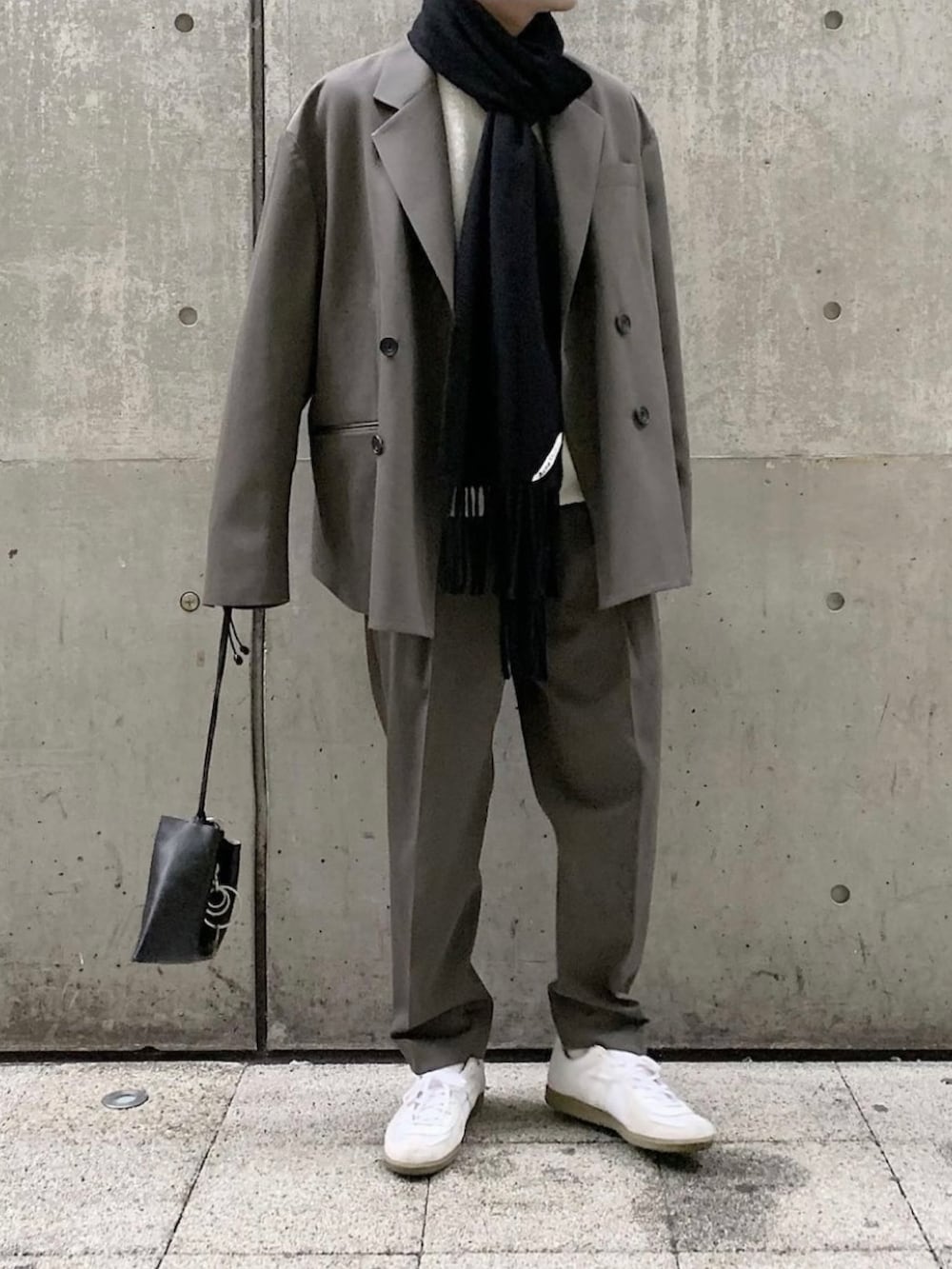 グレー系のセットアップ、グレー系のスラックス、ホワイト系のスニーカーを着用したメンズの秋コーディネートの2枚目の写真
