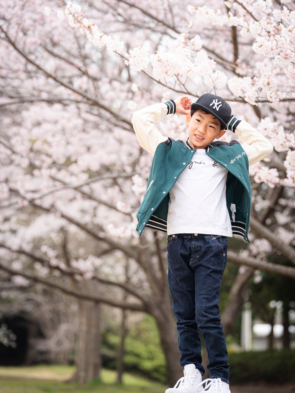 ホワイト系のTシャツ/カットソー、グリーン系のジャケット/アウター、ブルー系のデニムパンツを着用したキッズの春コーディネートの2枚目の写真