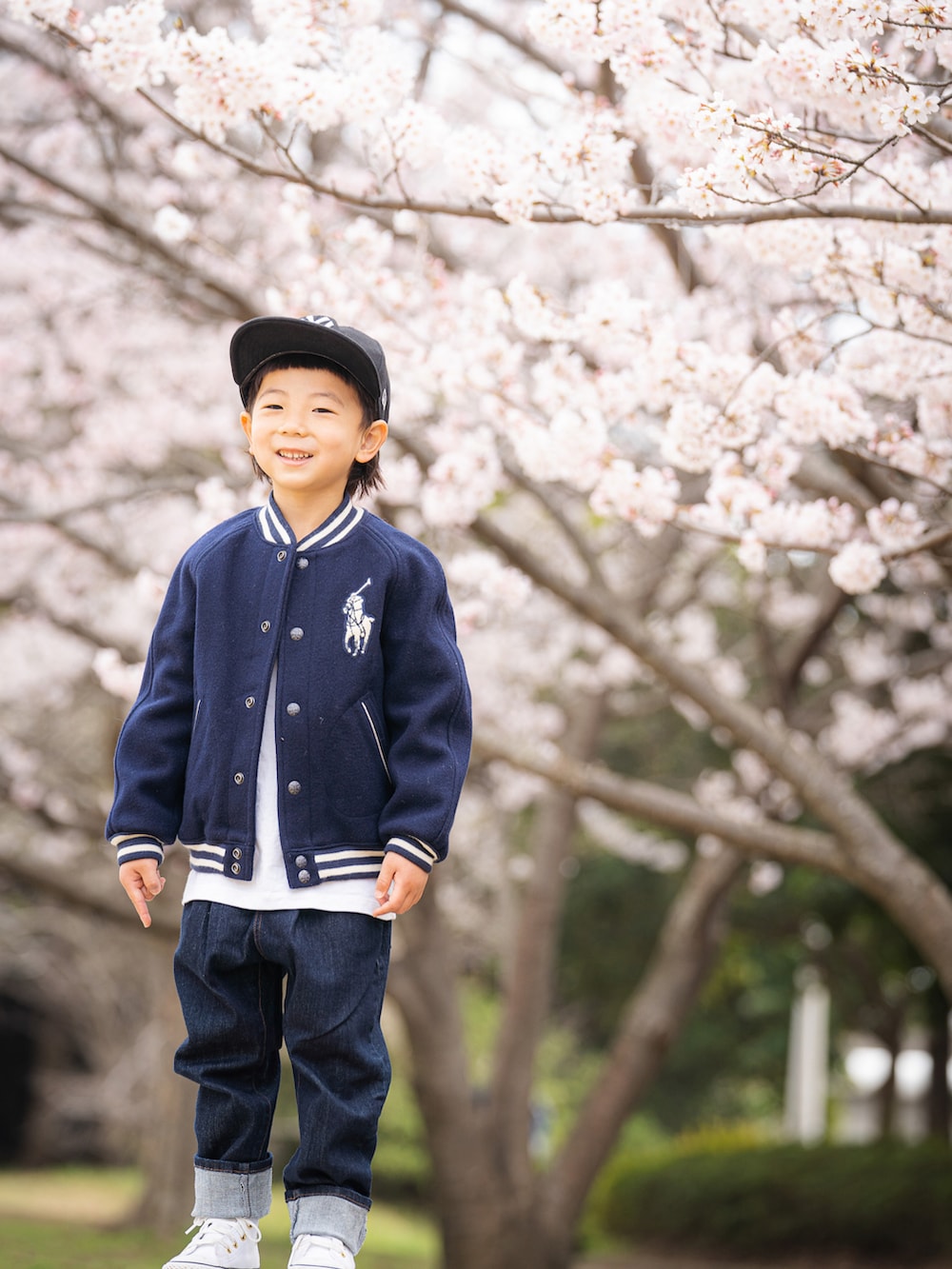 ホワイト系のTシャツ/カットソー、グリーン系のジャケット/アウター、ブルー系のデニムパンツを着用したキッズの春コーディネートの3枚目の写真