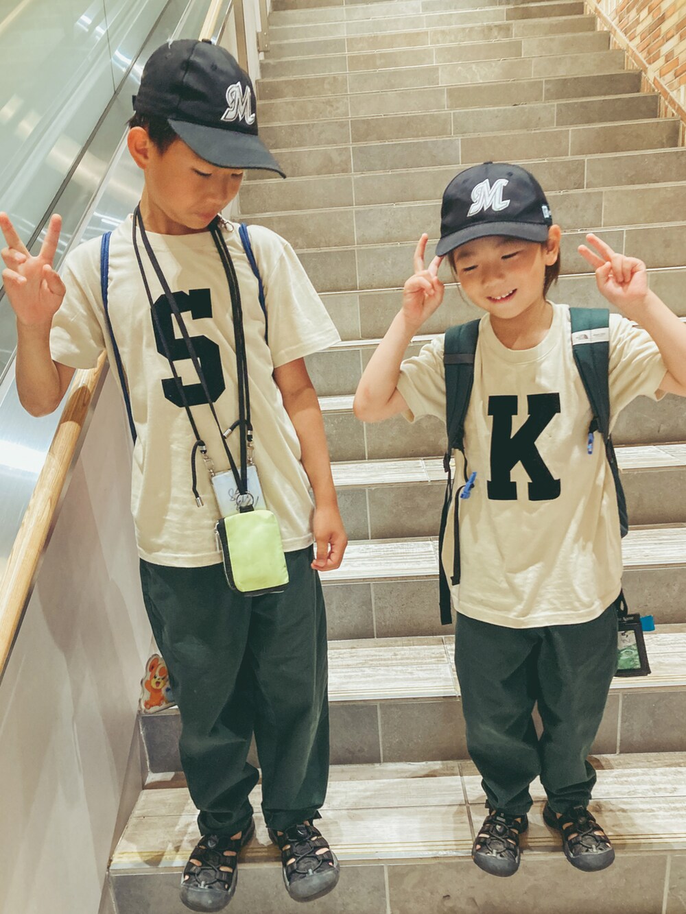 グリーン系のパンツ、ブラック系のサンダル、グリーン系のバックパック/リュックを着用したキッズの夏コーディネートの2枚目の写真