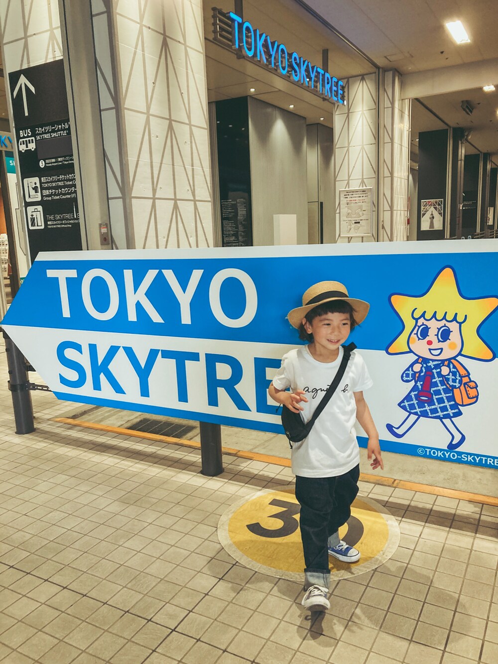 ブラック系のショルダーバッグ、ホワイト系のTシャツ/カットソー、ブルー系のデニムパンツを着用したキッズの春コーディネートの3枚目の写真