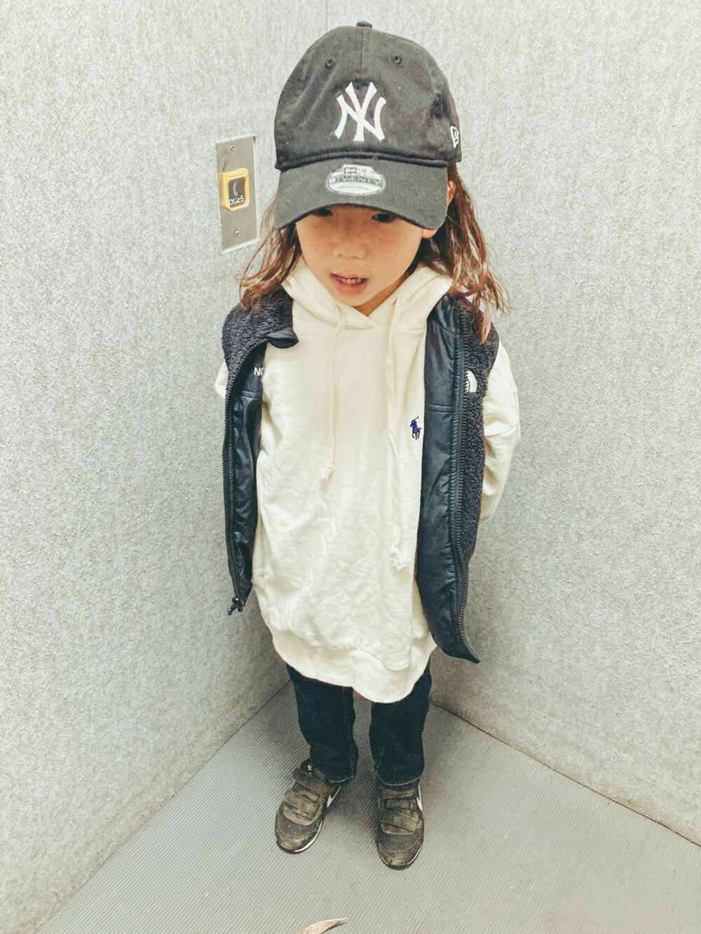 ブルー系のデニムパンツ、ブラック系のスニーカー、ブラック系のキャップを着用したキッズの冬コーディネートの2枚目の写真