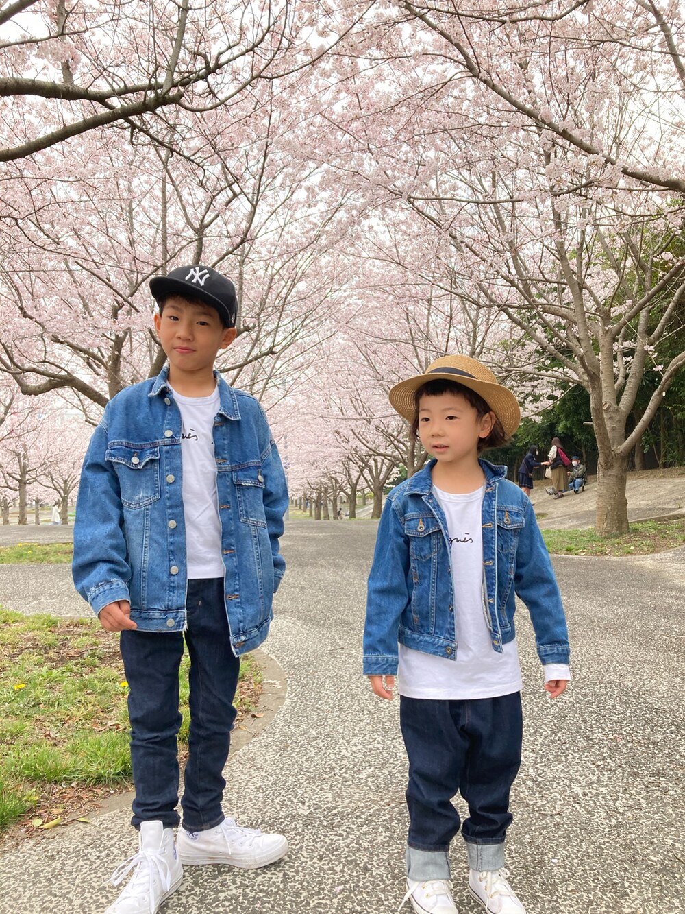 ブルー系のデニムパンツ、ホワイト系のスニーカー、ホワイト系のTシャツ/カットソーを着用したキッズの春コーディネートの2枚目の写真